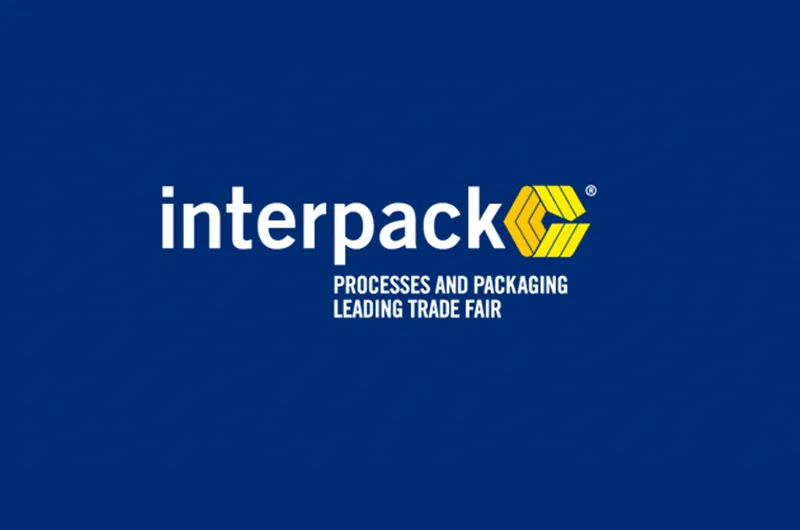 شعار معرض interpack على خلفية كحلية